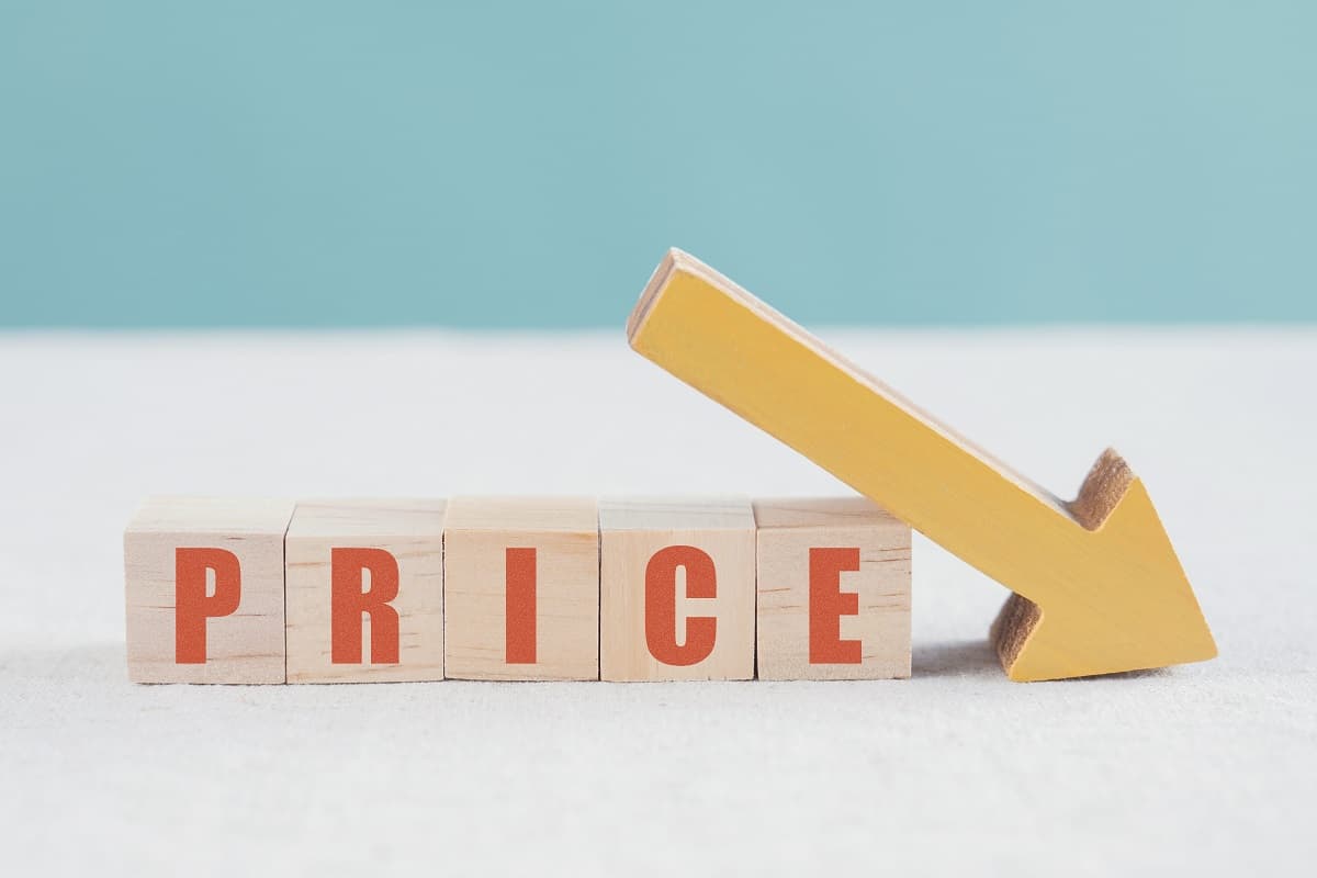 Cubes en bois inscrits "Price" et flèche descendante rouge, car Sosh a beaucoup baissé son prix moyen au giga